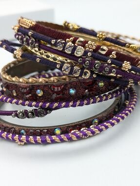 Colourful selection of gold tone and thread bangle bracelets